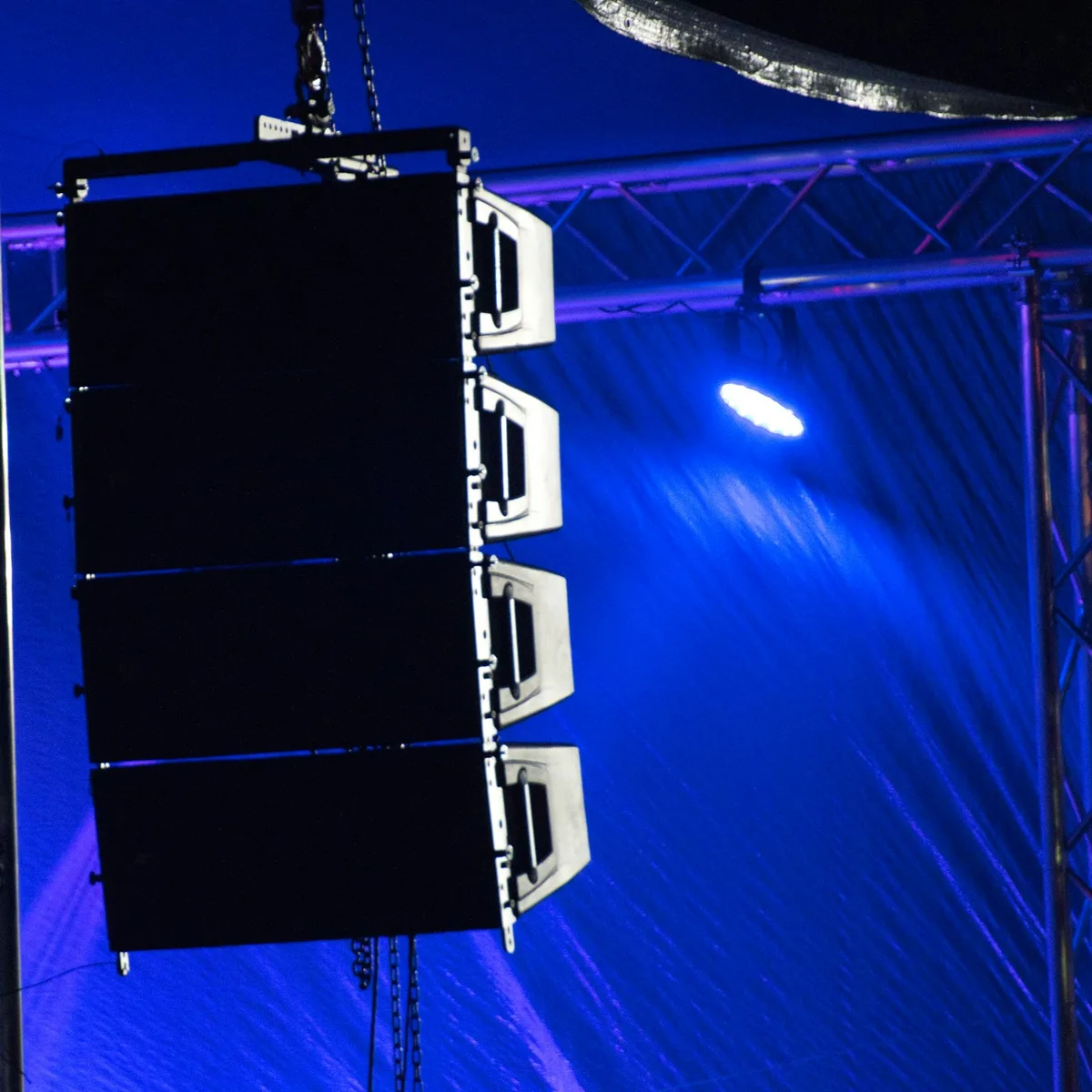 Concert speakers hanging suspended off the side of the stage