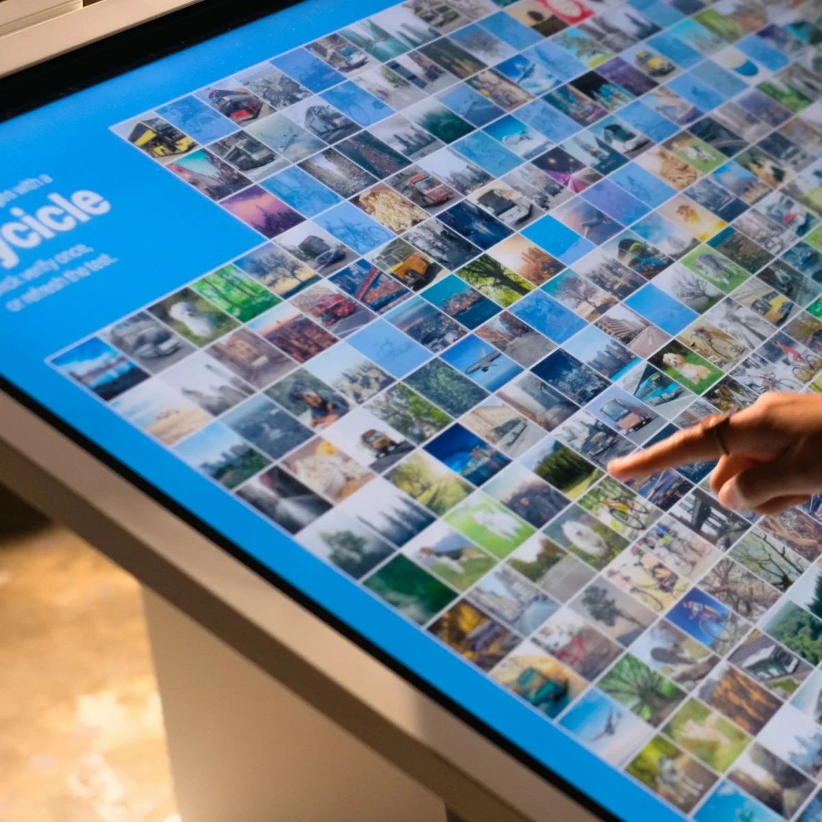 a person pointing at a large display of pictures