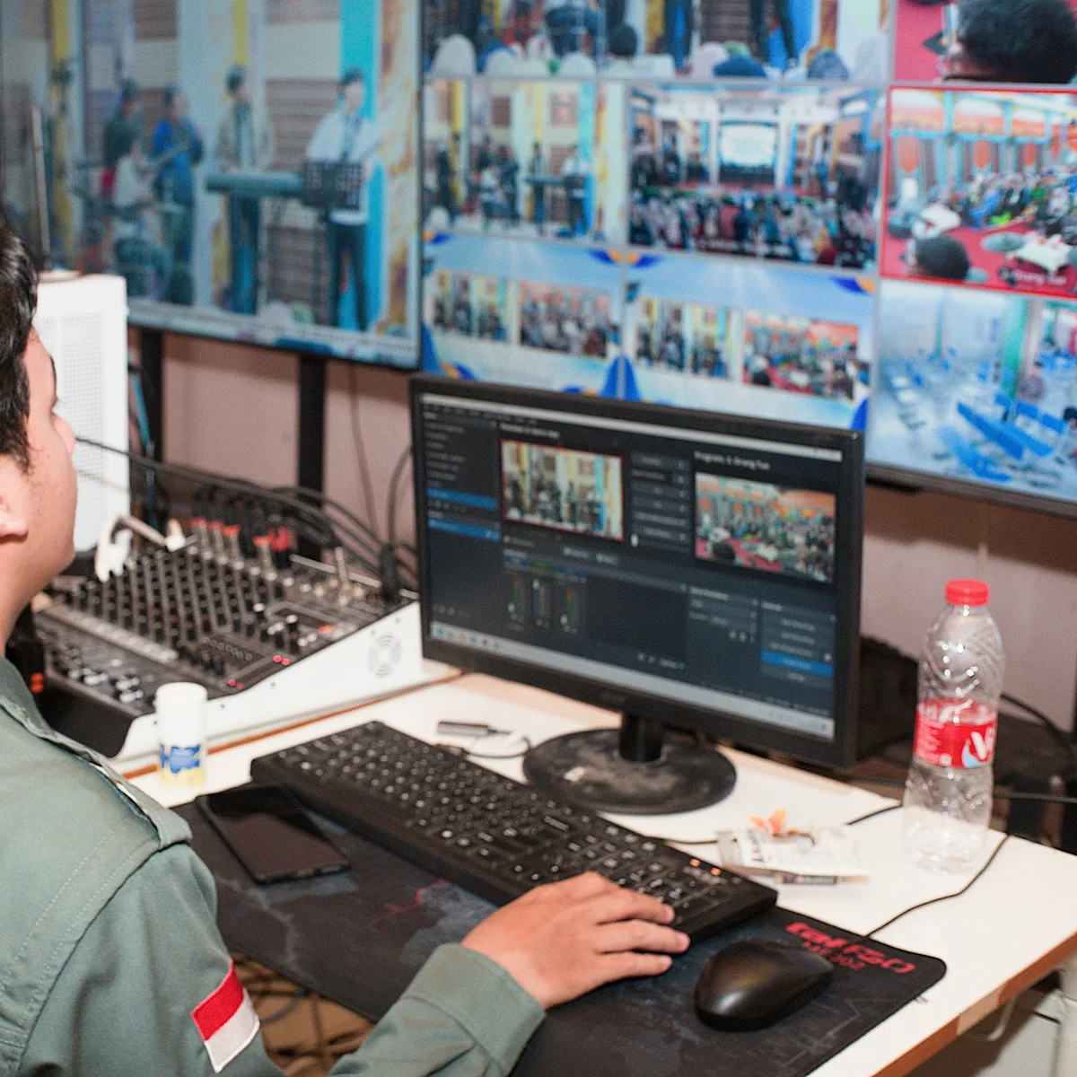 Man in uniform operating video and audio equipment.