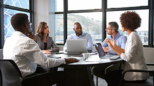 Team collaborating using rented MacBooks in a modern workspace.